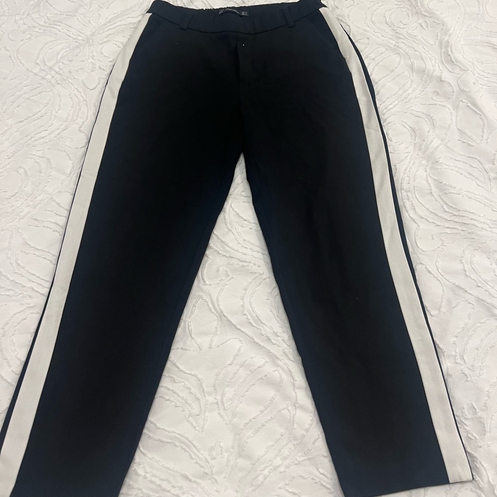 Black cropped pants with white stripes.